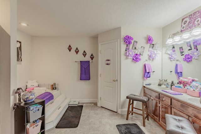 bathroom featuring double vanity, a sink, baseboards, recessed lighting, and a tub to relax in