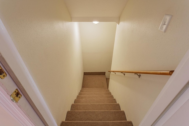 staircase featuring a textured wall