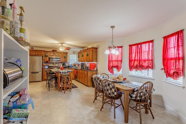dining area featuring a ceiling fan, baseboards, plenty of natural light, and light floors