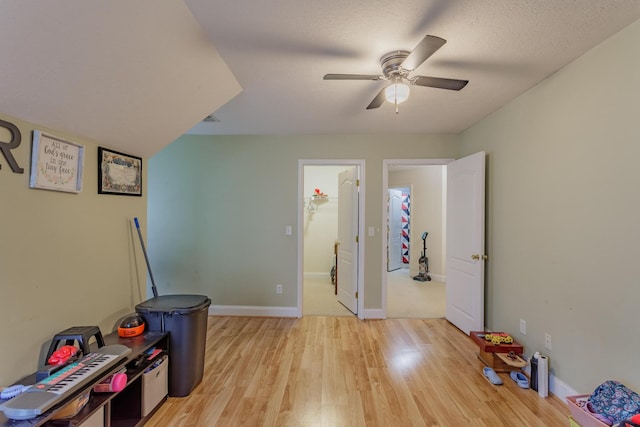 playroom featuring baseboards, light wood-style flooring, and ceiling fan