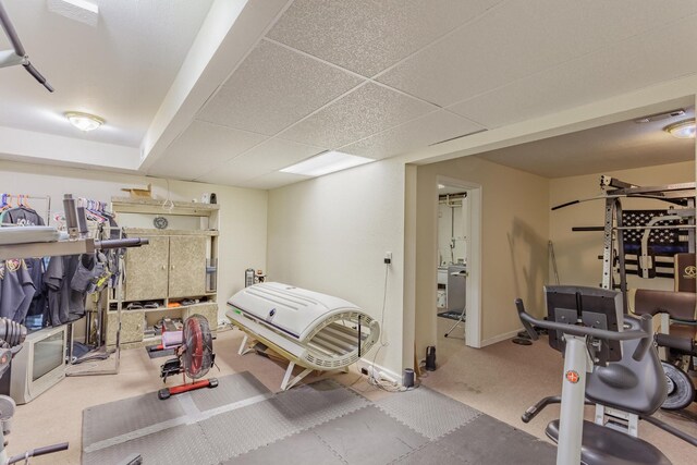 exercise area with carpet flooring, baseboards, visible vents, and a drop ceiling