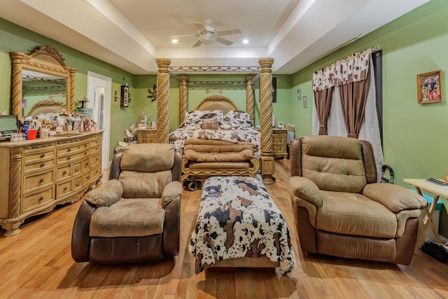 bedroom featuring recessed lighting, a tray ceiling, ceiling fan, and light wood-type flooring