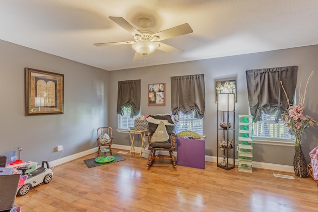 recreation room with ceiling fan, visible vents, a healthy amount of sunlight, and wood finished floors