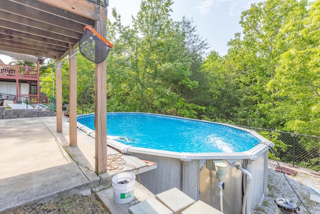 outdoor pool with fence and a patio area