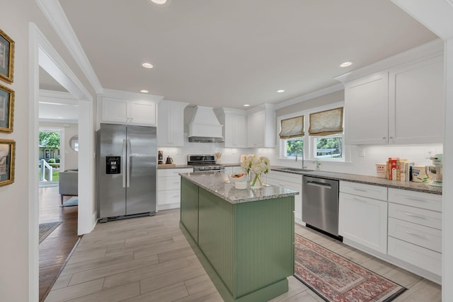 kitchen featuring backsplash, white cabinetry, appliances with stainless steel finishes, and custom exhaust hood