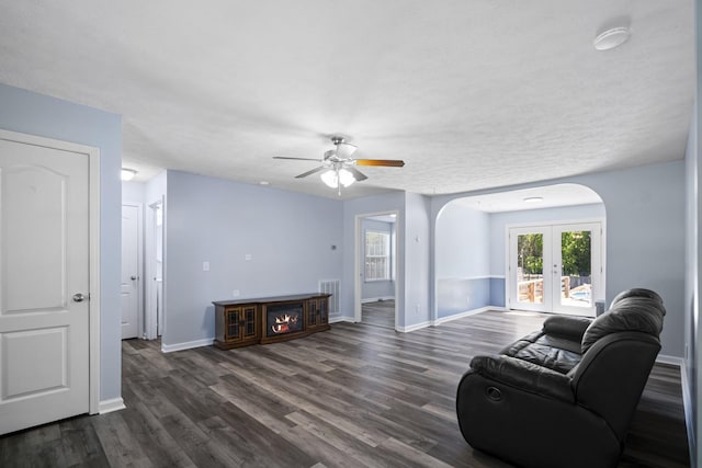 6241 Eskew Dr, Columbia, TN 38401 - living area with french doors, arched walkways, a ceiling fan, dark wood-style floors, and baseboards