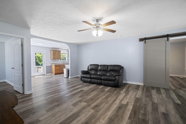 6241 Eskew Dr, Columbia, TN 38401 - living area with a barn door, dark wood-type flooring, ceiling fan, and baseboards