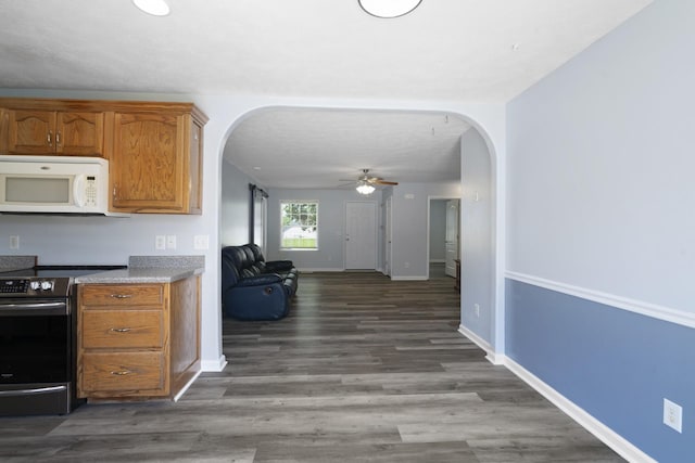 6241 Eskew Dr, Columbia, TN 38401 - kitchen with white microwave, electric range, arched walkways, a ceiling fan, and brown cabinetry