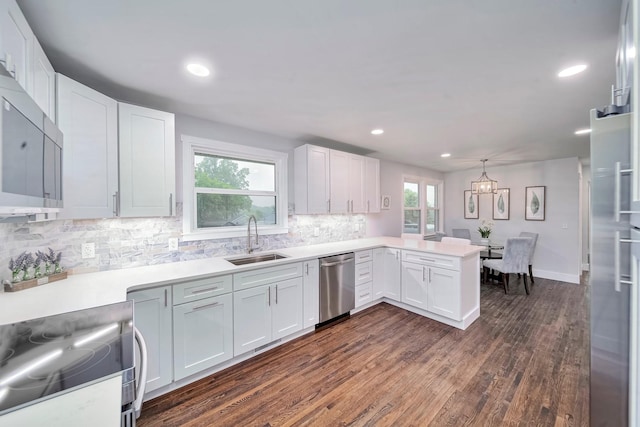 210 NW Clearview Dr, Mount Juliet, TN 37122 - kitchen featuring decorative backsplash, appliances with stainless steel finishes, dark wood finished floors, a sink, and a peninsula