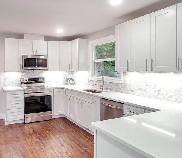 210 NW Clearview Dr, Mount Juliet, TN 37122 - kitchen featuring stainless steel appliances, a sink, light countertops, white cabinetry, and recessed lighting