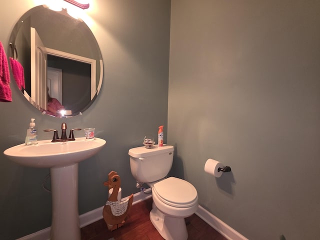 bathroom featuring baseboards, toilet, and wood finished floors
