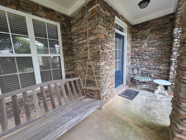 entrance to property featuring a porch and stone siding