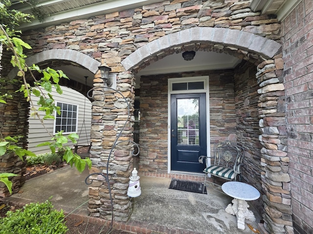 property entrance with stone siding and brick siding