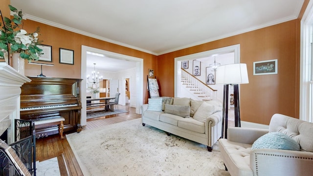living room featuring stairway, ornamental molding, wood finished floors, and a chandelier