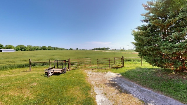 view of yard featuring fence, a gate, and a rural view