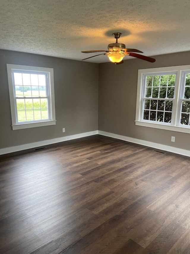 11495 Guthrie Rd, Guthrie, KY 42234 - spare room featuring dark wood-style flooring, ceiling fan, visible vents, and a healthy amount of sunlight