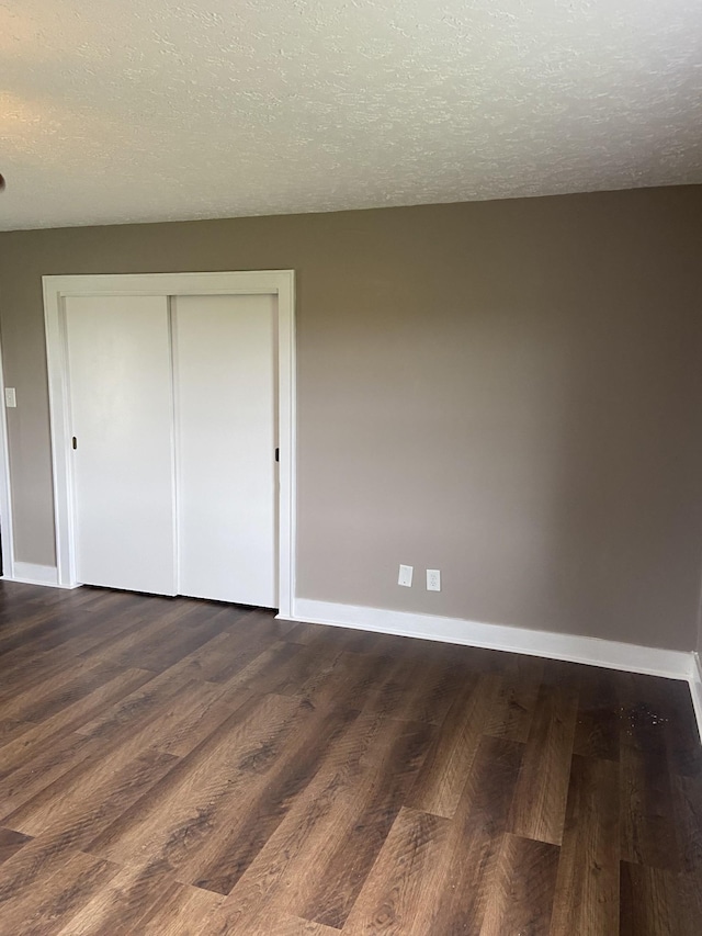 11495 Guthrie Rd, Guthrie, KY 42234 - unfurnished bedroom with baseboards, a textured ceiling, and dark wood finished floors