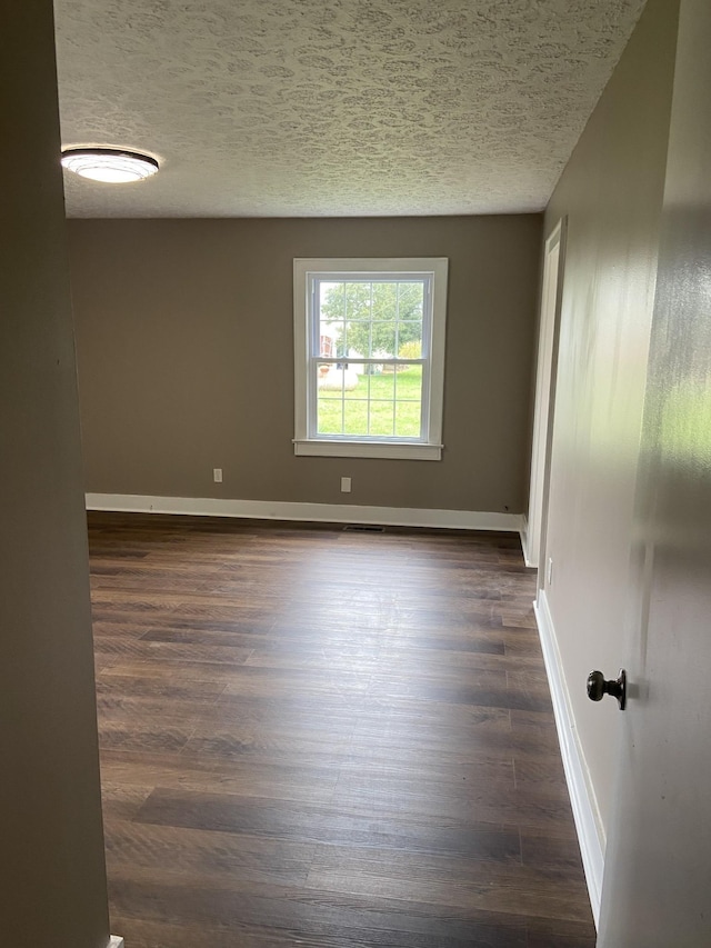 11495 Guthrie Rd, Guthrie, KY 42234 - empty room featuring baseboards, visible vents, a textured ceiling, and dark wood-type flooring