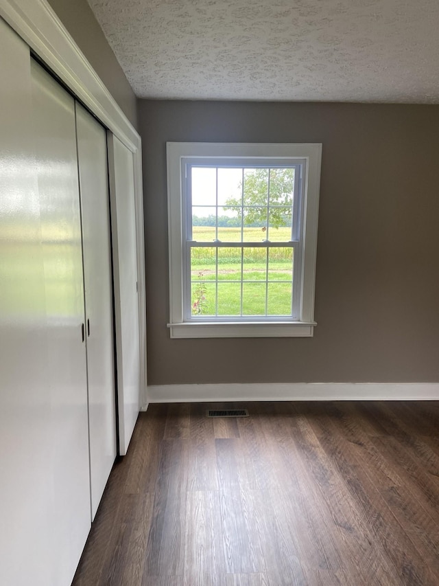 11495 Guthrie Rd, Guthrie, KY 42234 - interior space with dark wood-style flooring, a textured ceiling, visible vents, and baseboards
