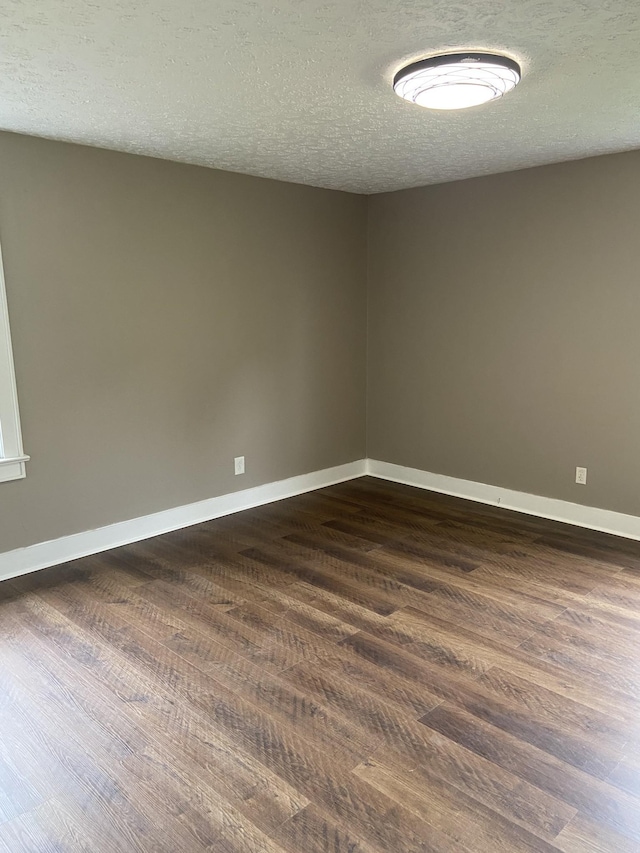 11495 Guthrie Rd, Guthrie, KY 42234 - empty room with baseboards, dark wood finished floors, and a textured ceiling