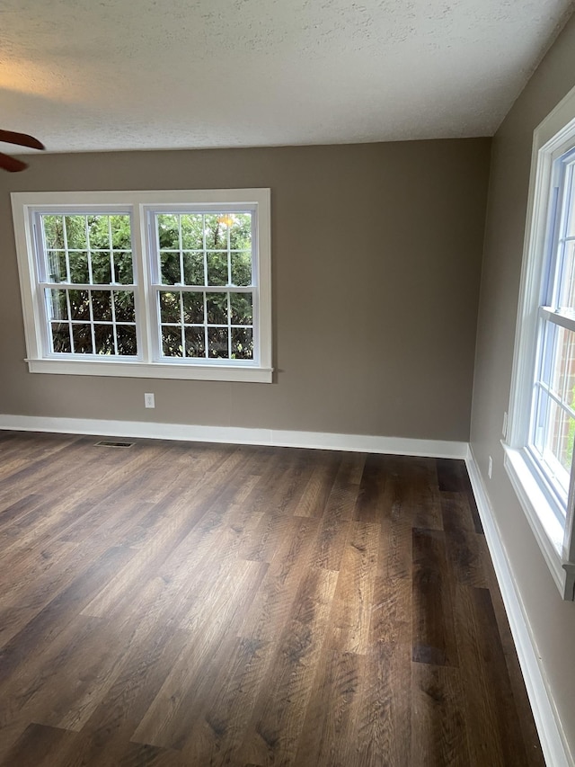 11495 Guthrie Rd, Guthrie, KY 42234 - unfurnished room with baseboards, a ceiling fan, dark wood finished floors, and visible vents