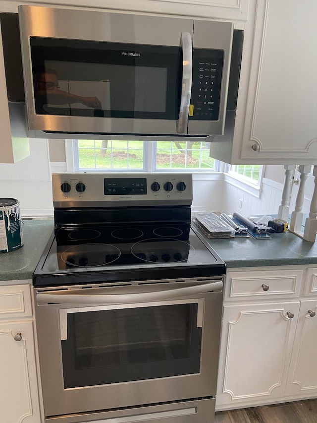 11495 Guthrie Rd, Guthrie, KY 42234 - kitchen featuring white cabinets, stainless steel appliances, dark countertops, and wood finished floors