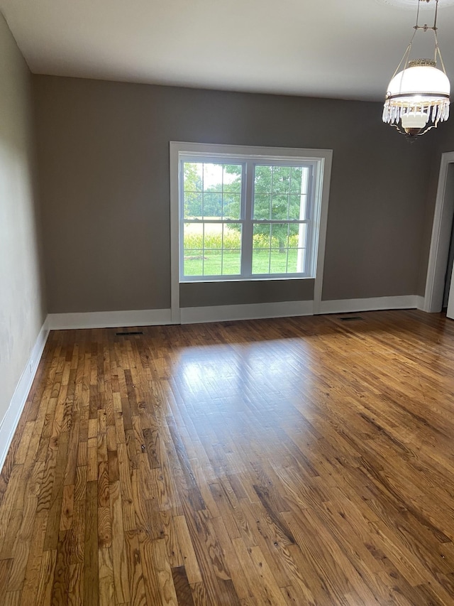 11495 Guthrie Rd, Guthrie, KY 42234 - spare room featuring baseboards, a notable chandelier, and dark wood-type flooring