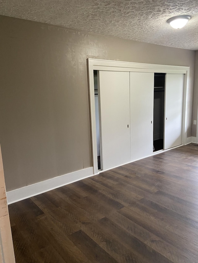 11495 Guthrie Rd, Guthrie, KY 42234 - unfurnished bedroom featuring a closet, dark wood-style floors, and a textured ceiling