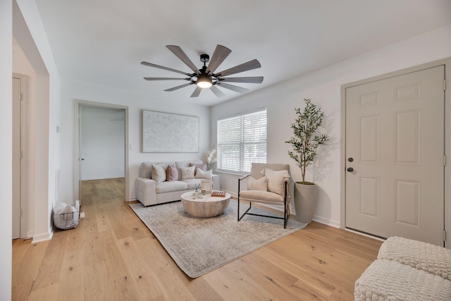 living room featuring light wood-type flooring, baseboards, and ceiling fan