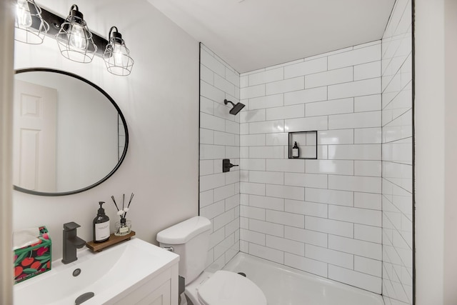 full bathroom with vanity, a tile shower, and toilet