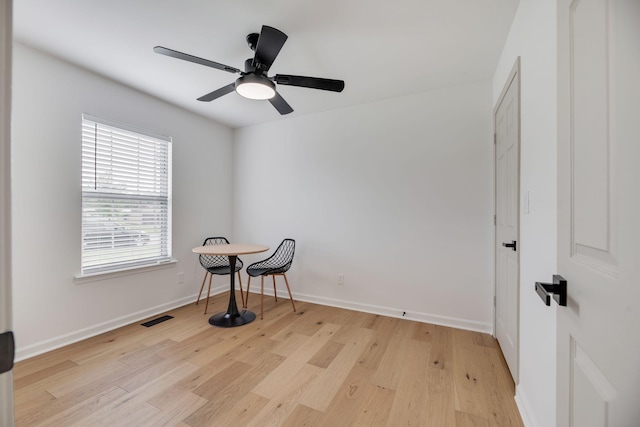 empty room featuring visible vents, a ceiling fan, baseboards, and light wood-type flooring