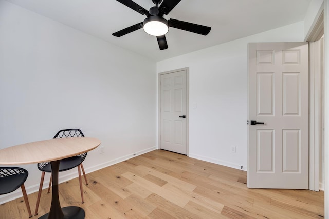 interior space with baseboards, a ceiling fan, and light wood finished floors