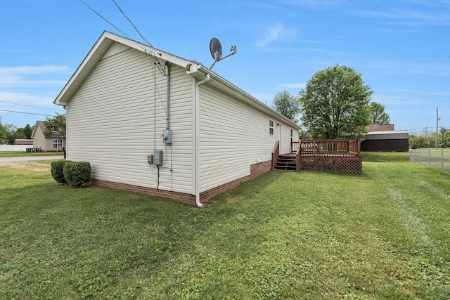 view of side of home featuring a yard, a deck, and fence