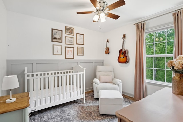 557 Skyview Dr, Ashland City, TN 37015 - bedroom with a ceiling fan, a crib, wood finished floors, and a decorative wall