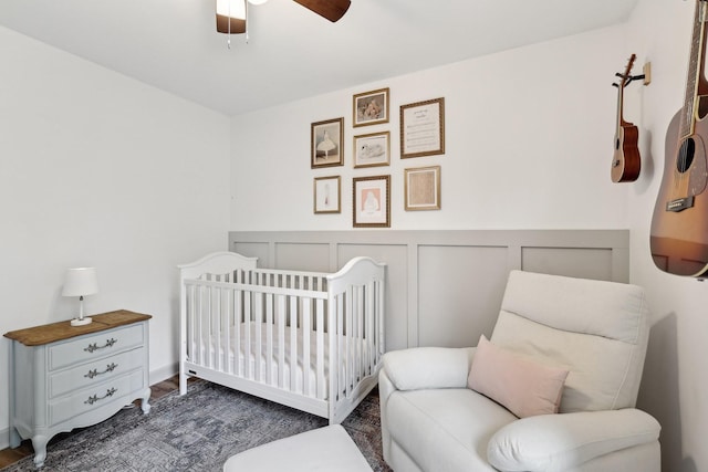 557 Skyview Dr, Ashland City, TN 37015 - bedroom featuring wood finished floors, a nursery area, a wainscoted wall, and a decorative wall