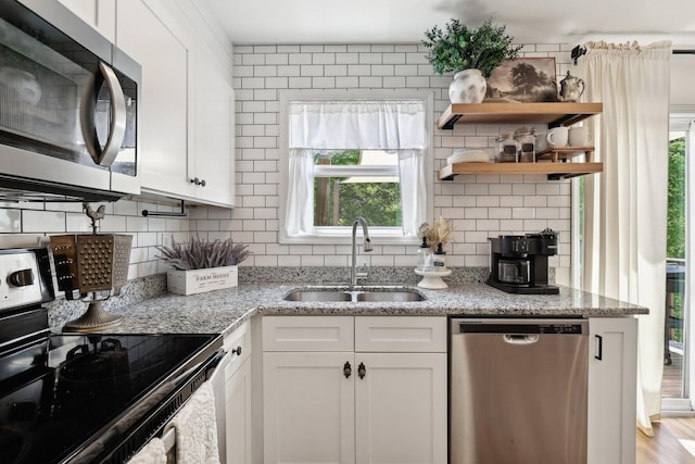 557 Skyview Dr, Ashland City, TN 37015 - kitchen with light stone counters, a sink, appliances with stainless steel finishes, and tasteful backsplash