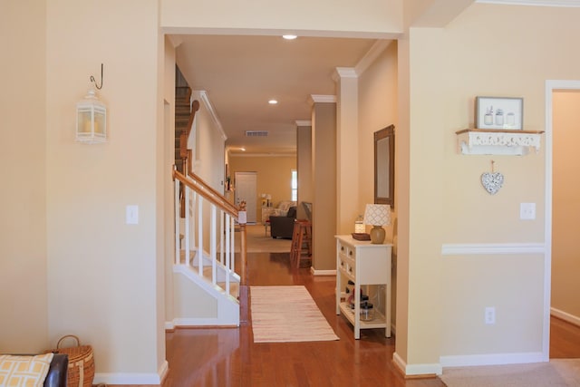 corridor with baseboards, ornamental molding, stairs, and wood finished floors