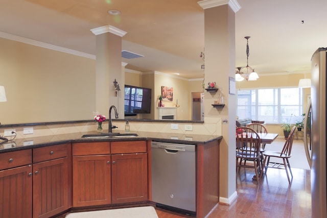 kitchen with a sink, stainless steel appliances, backsplash, ornate columns, and ornamental molding