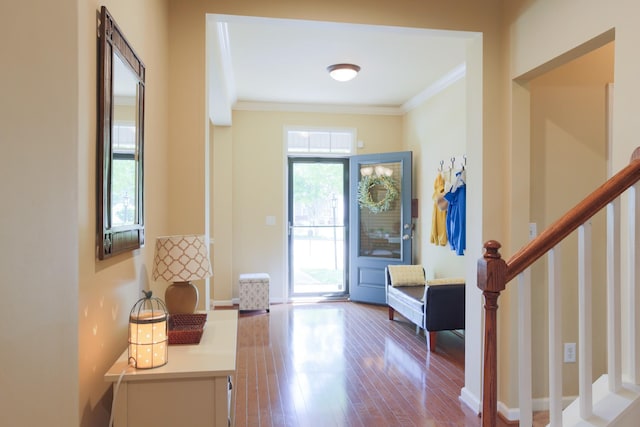 doorway featuring crown molding, dark wood-style flooring, baseboards, and stairway