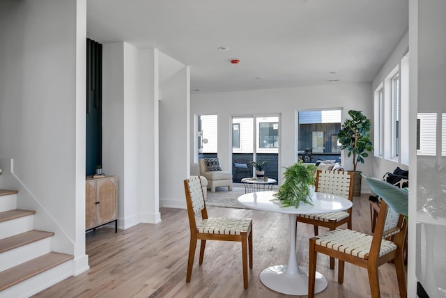 dining room with light wood-style floors, recessed lighting, baseboards, and stairway