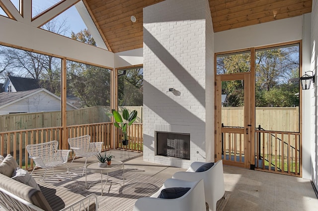 sunroom / solarium featuring an outdoor living space with a fireplace