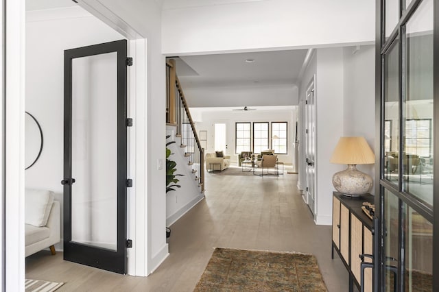 foyer featuring french doors, baseboards, wood finished floors, and stairway