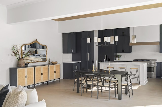 kitchen with light countertops, dark cabinets, stainless steel stove, and light wood-style floors