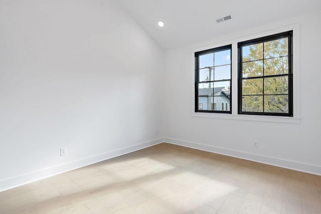 empty room with visible vents, recessed lighting, baseboards, and vaulted ceiling