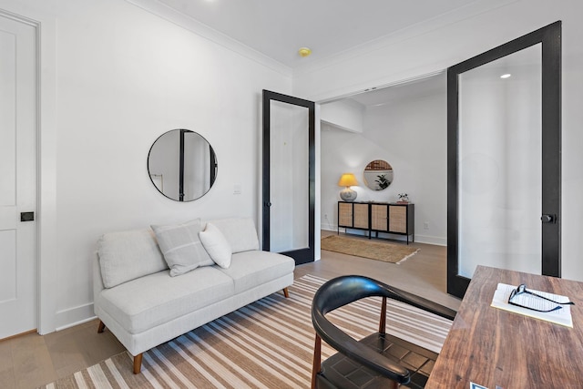 living room with crown molding, baseboards, and wood finished floors