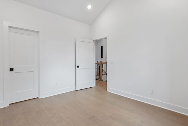 unfurnished bedroom featuring recessed lighting, baseboards, light wood finished floors, and high vaulted ceiling