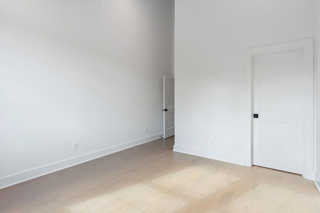 empty room featuring baseboards and light wood-style floors