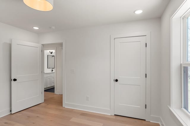 unfurnished bedroom with recessed lighting, baseboards, and light wood-style floors