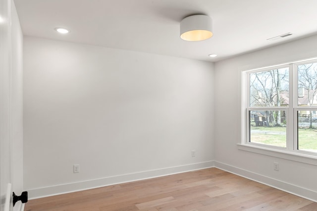 spare room with baseboards, visible vents, plenty of natural light, and light wood-style floors