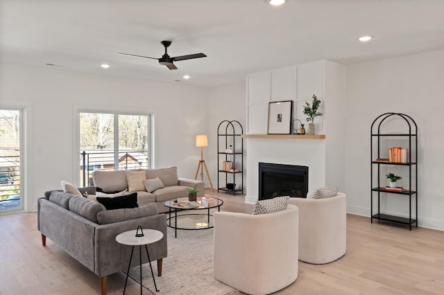 living room featuring ceiling fan, plenty of natural light, and light wood finished floors